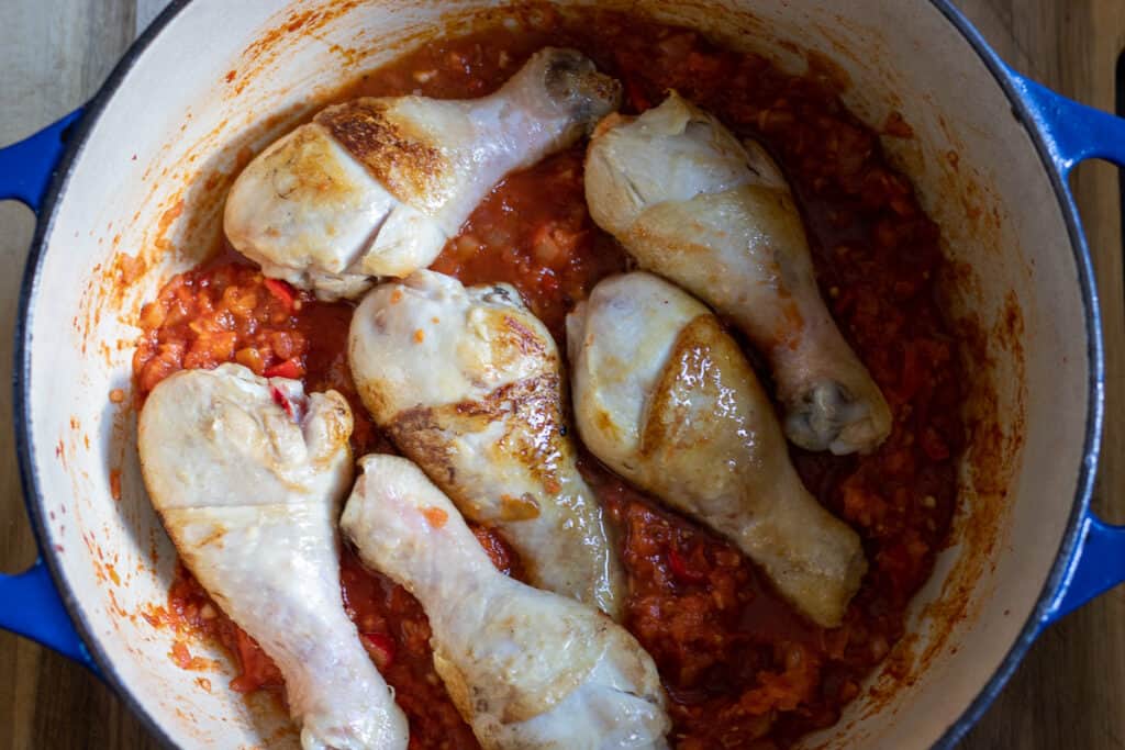 Chicken pieces are returned to the pot.