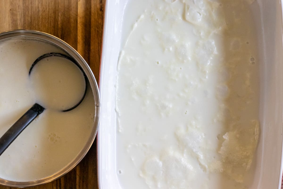 pouring a ladle of milk on gullac leaf
