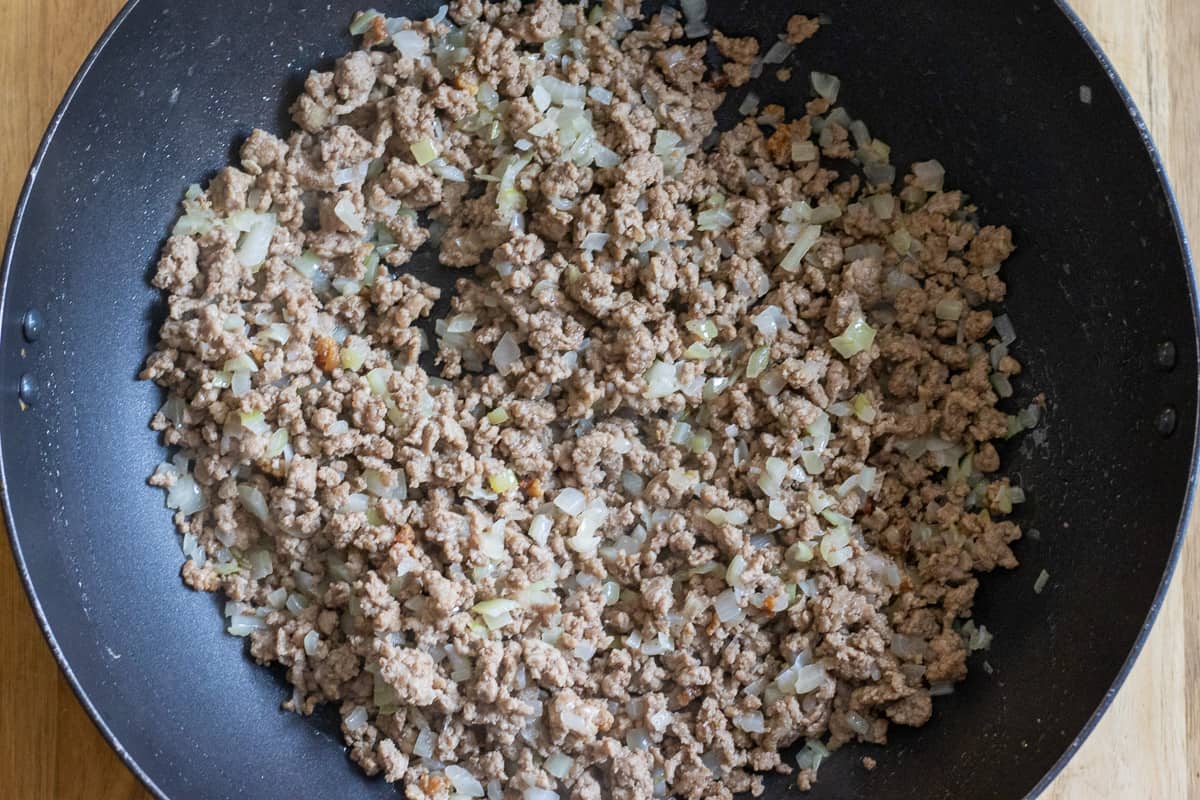 browned mince and sautéed onions in a pan