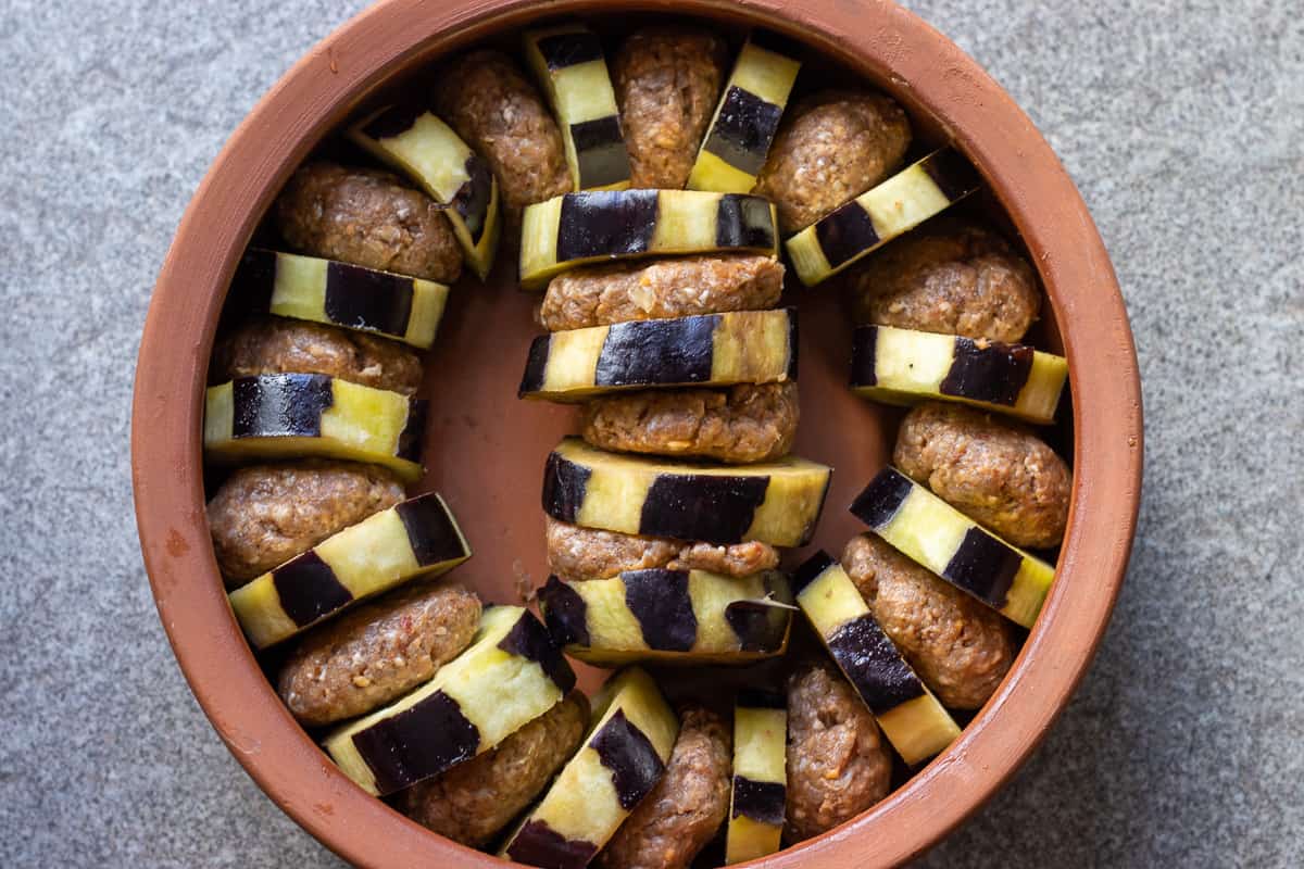 arranging the meatballs and aubergines into an oven dish