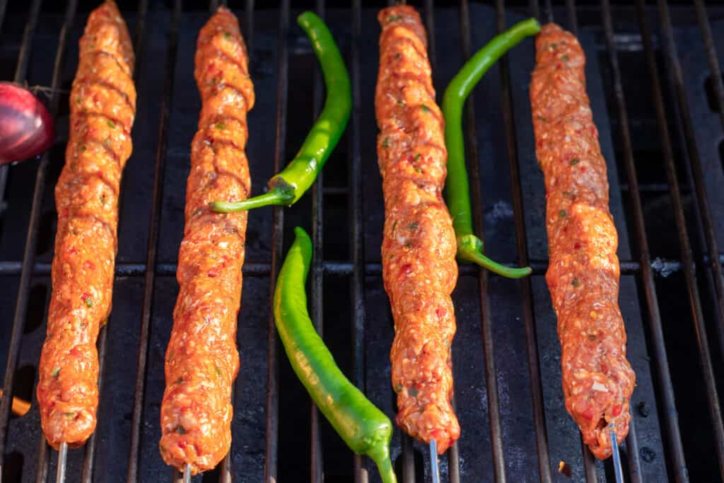 cooking Adana kebabs on BBQ