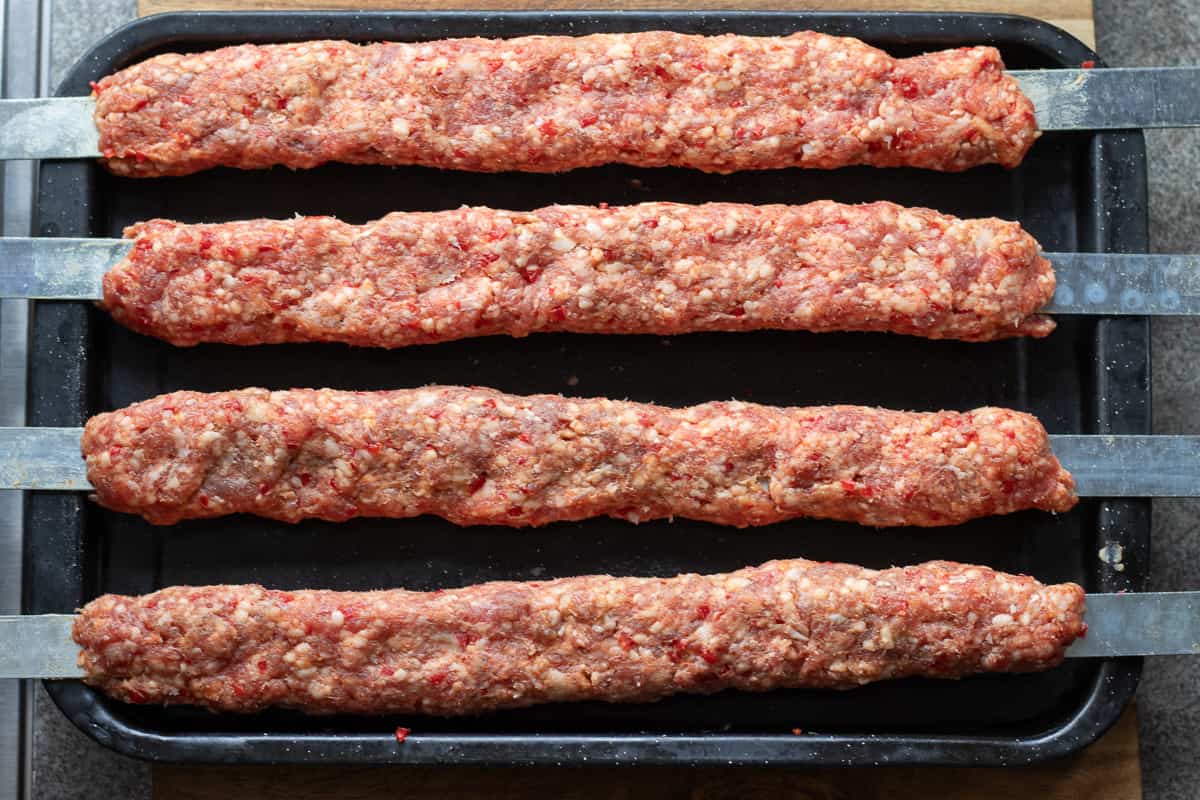 4 pieces of Adana Kebabs on skewers