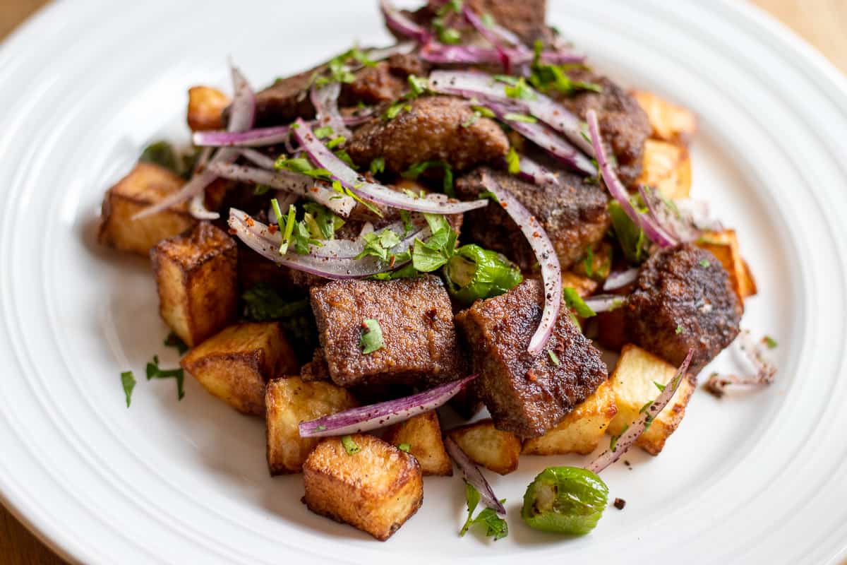 arnavut cigeri served with red onion salad and potato cubes