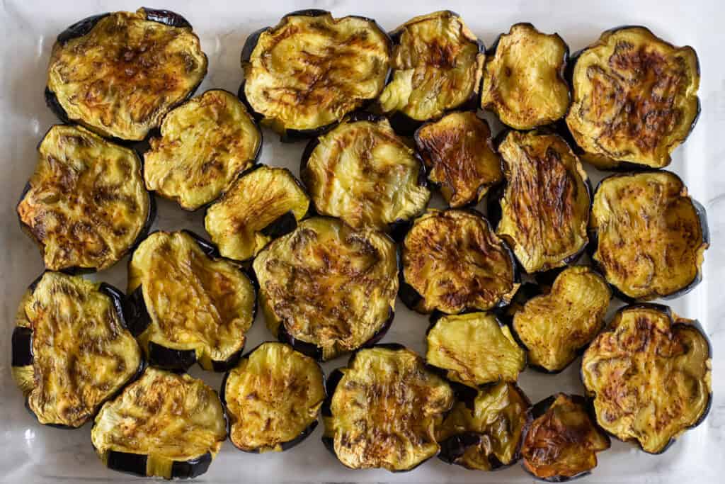 Fried eggplants are arranged in an oven dish.