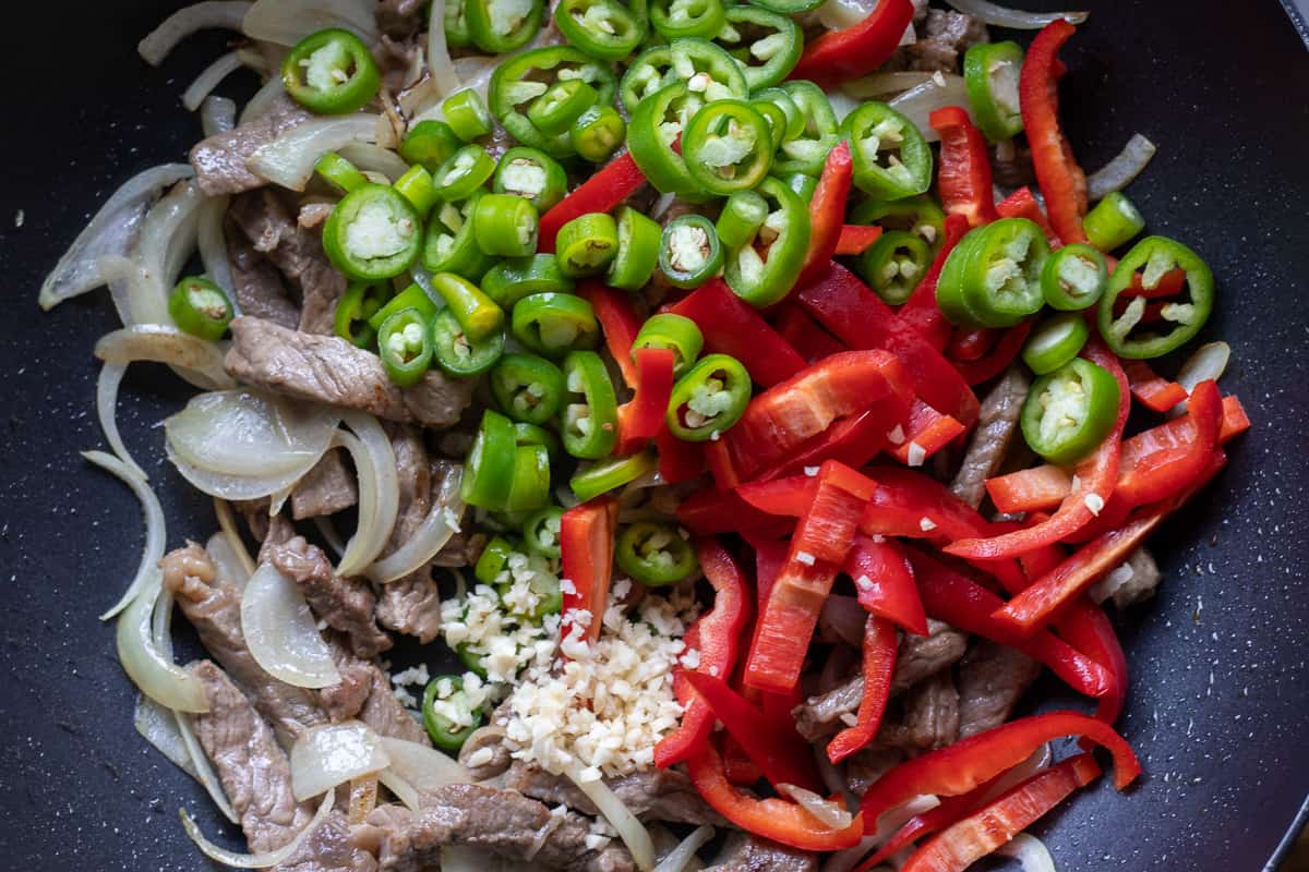 Sautéing the garlic and peppers to the pan
