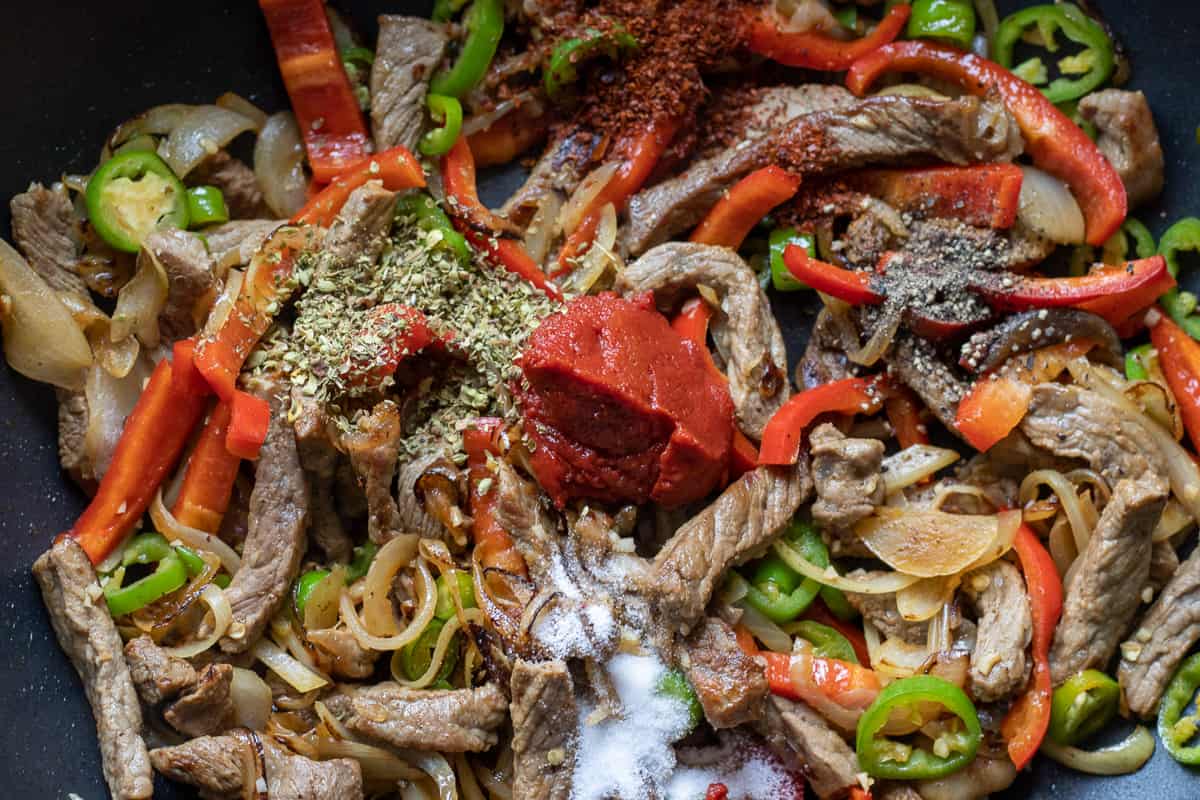 The tomato paste and spices are stirred in