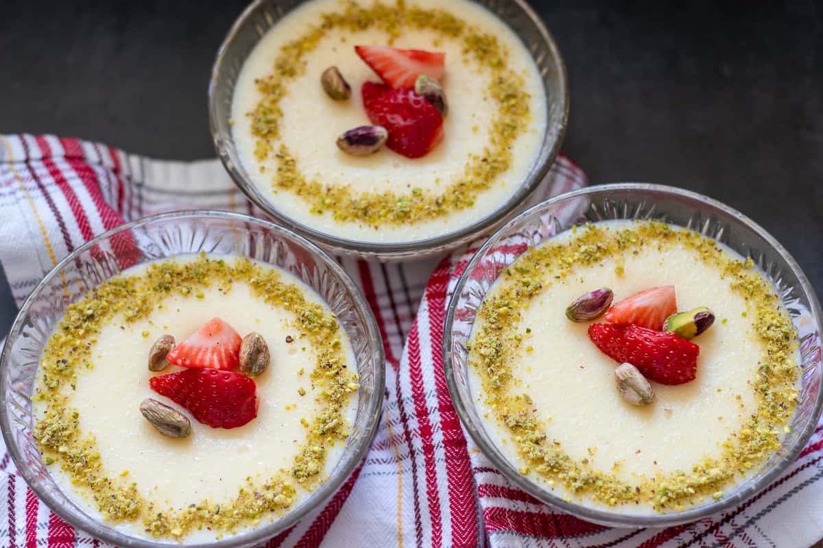 3 bowls of chilled keskul garnished with nuts and strawberries