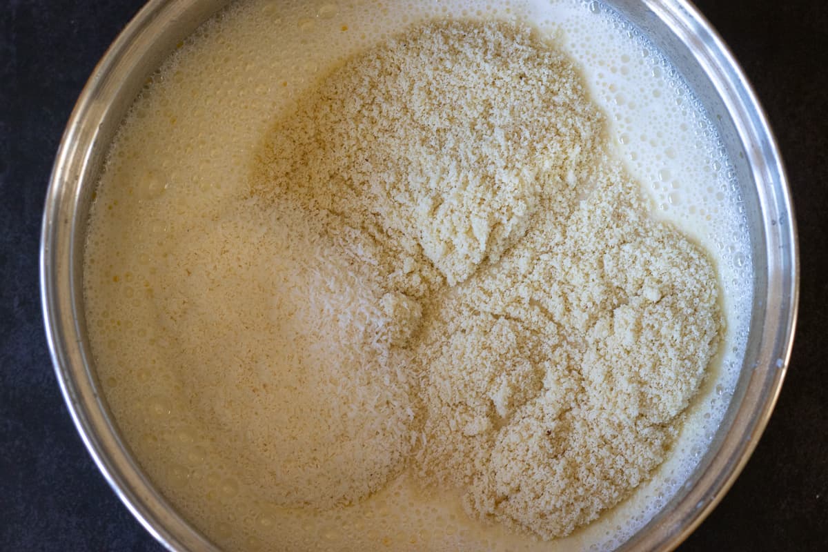Milk, the ground almond and coconut are added to the pan