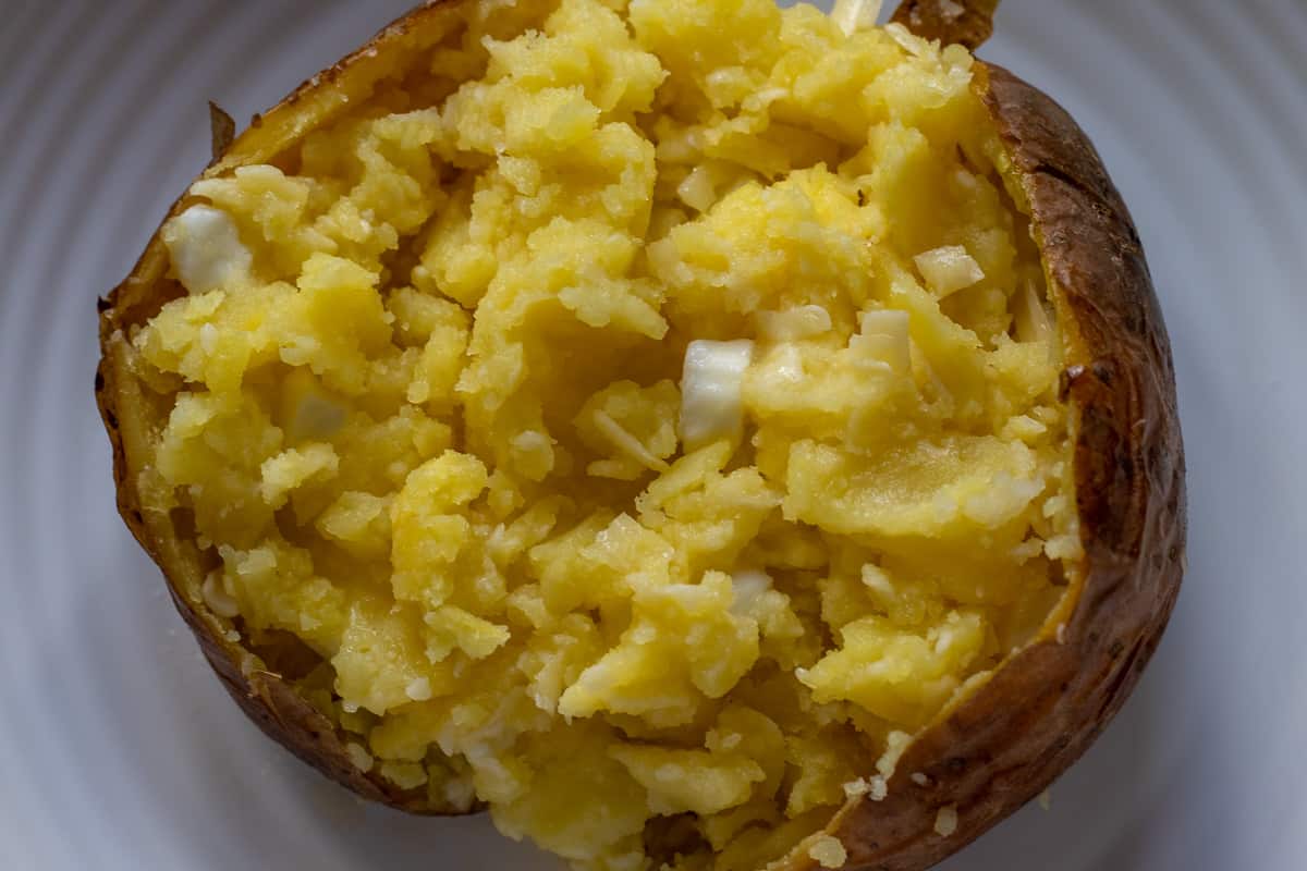 Butter and cheese added in a baked potato