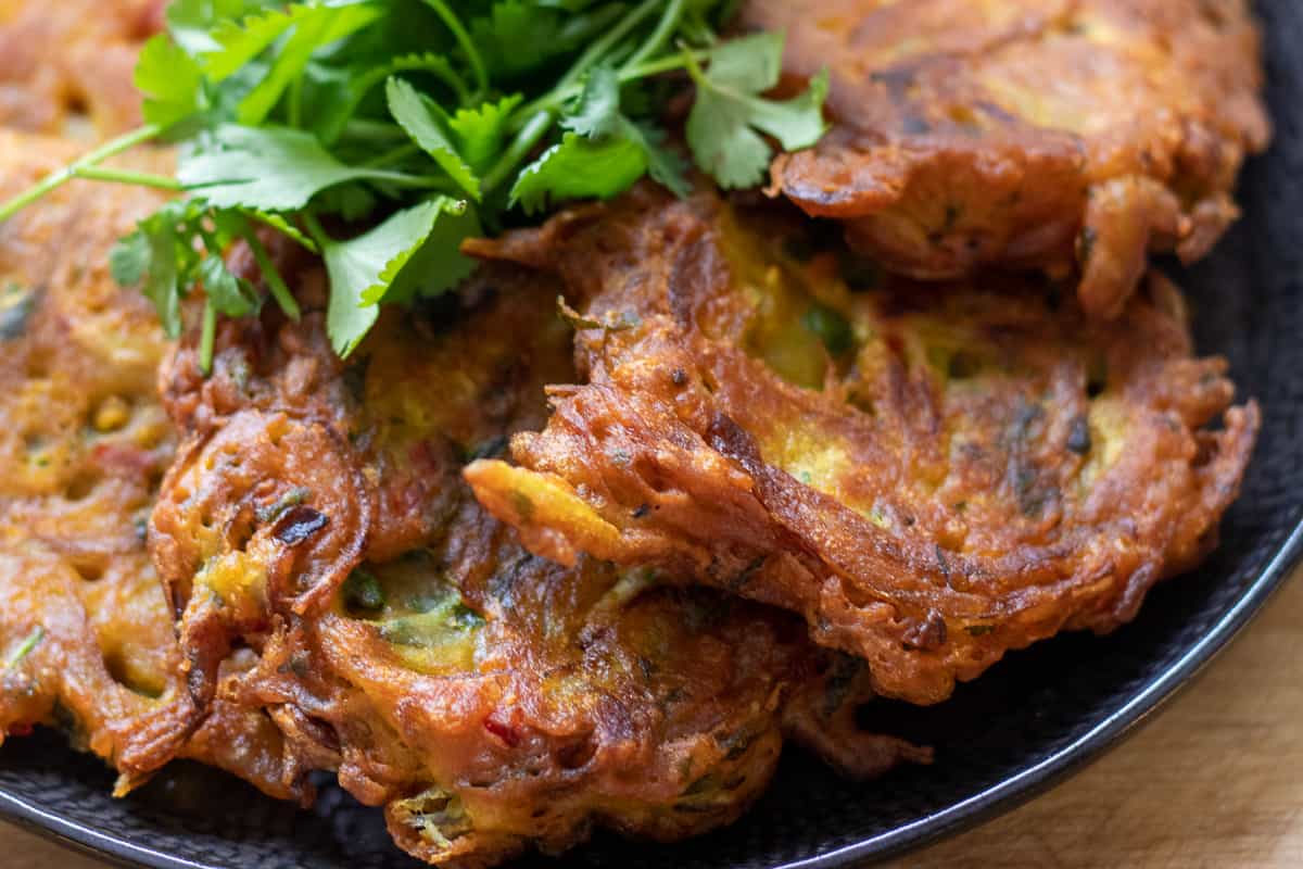 onion bhaji served on a plate with fresh coriander