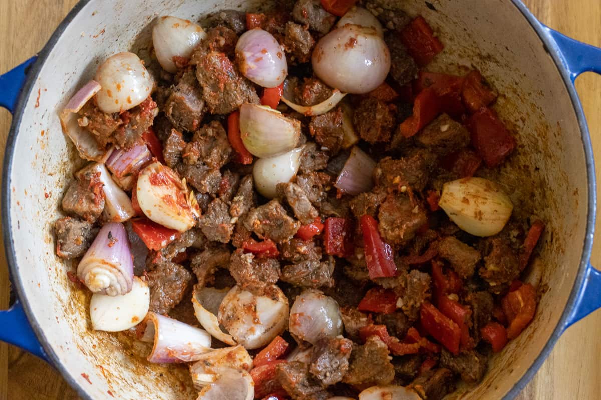 the tomato paste and seasoning are added to the pan