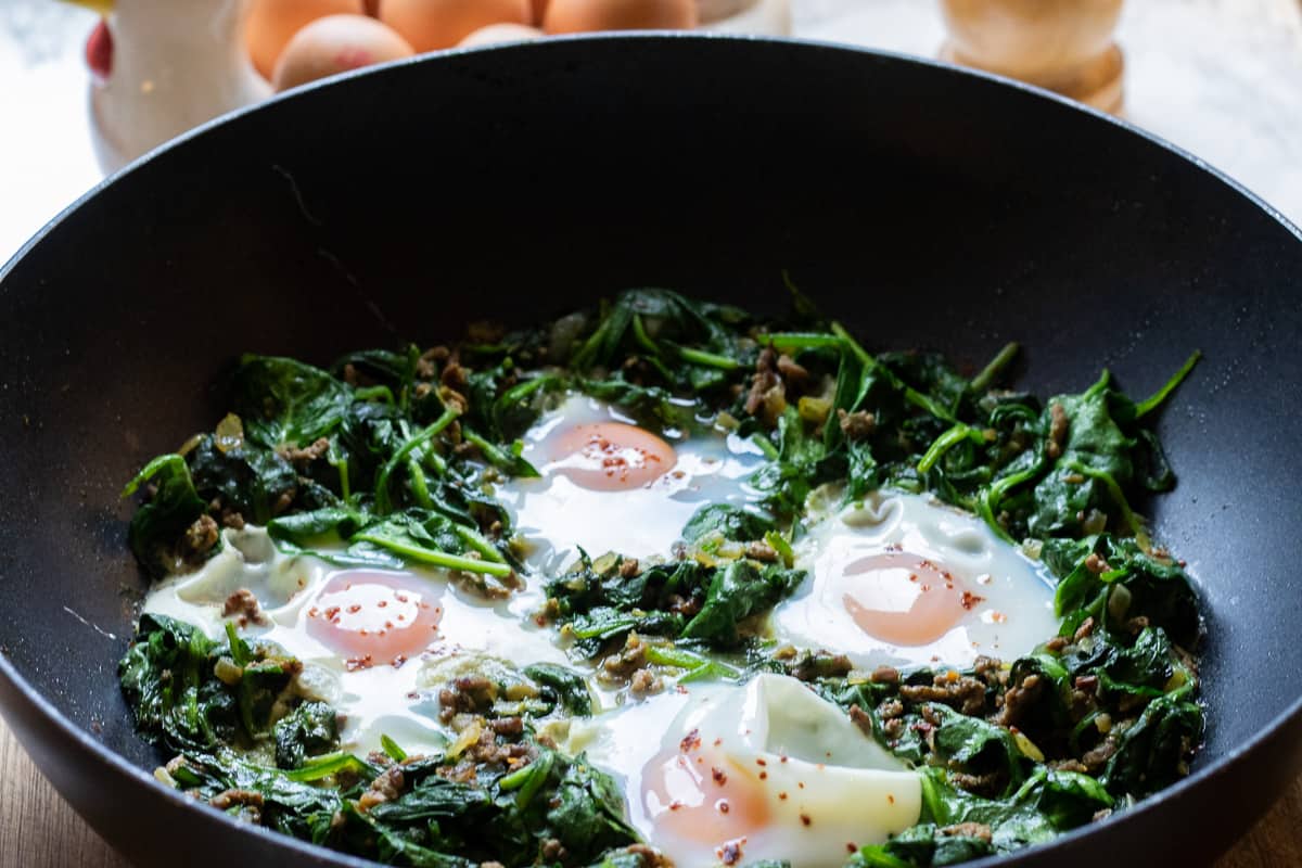 eggs cooked on a bed of spinach 