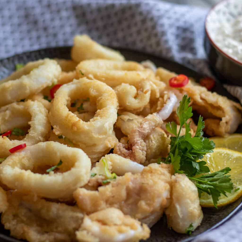 Fried calamari rings served with lemon wedges.