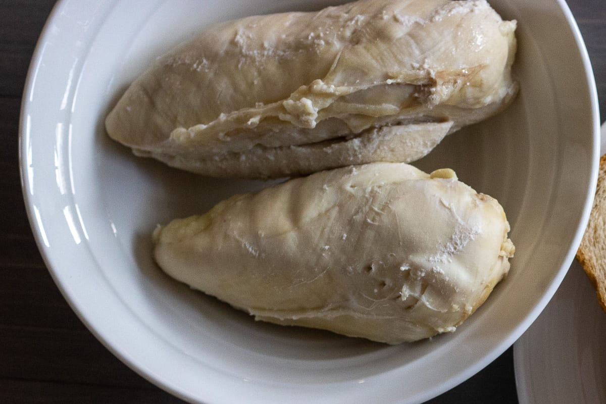 two poached chicken breasts in a bowl
