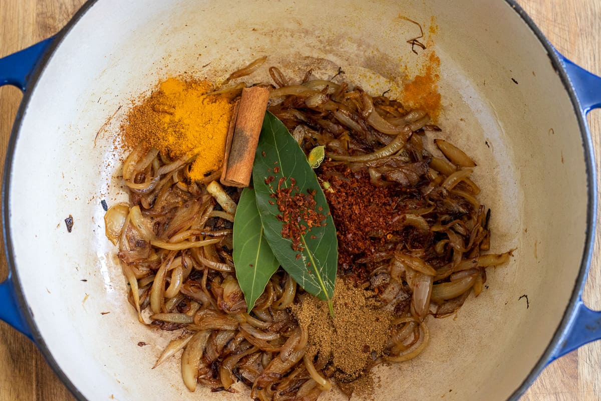 the spices are stirred in the dutch oven