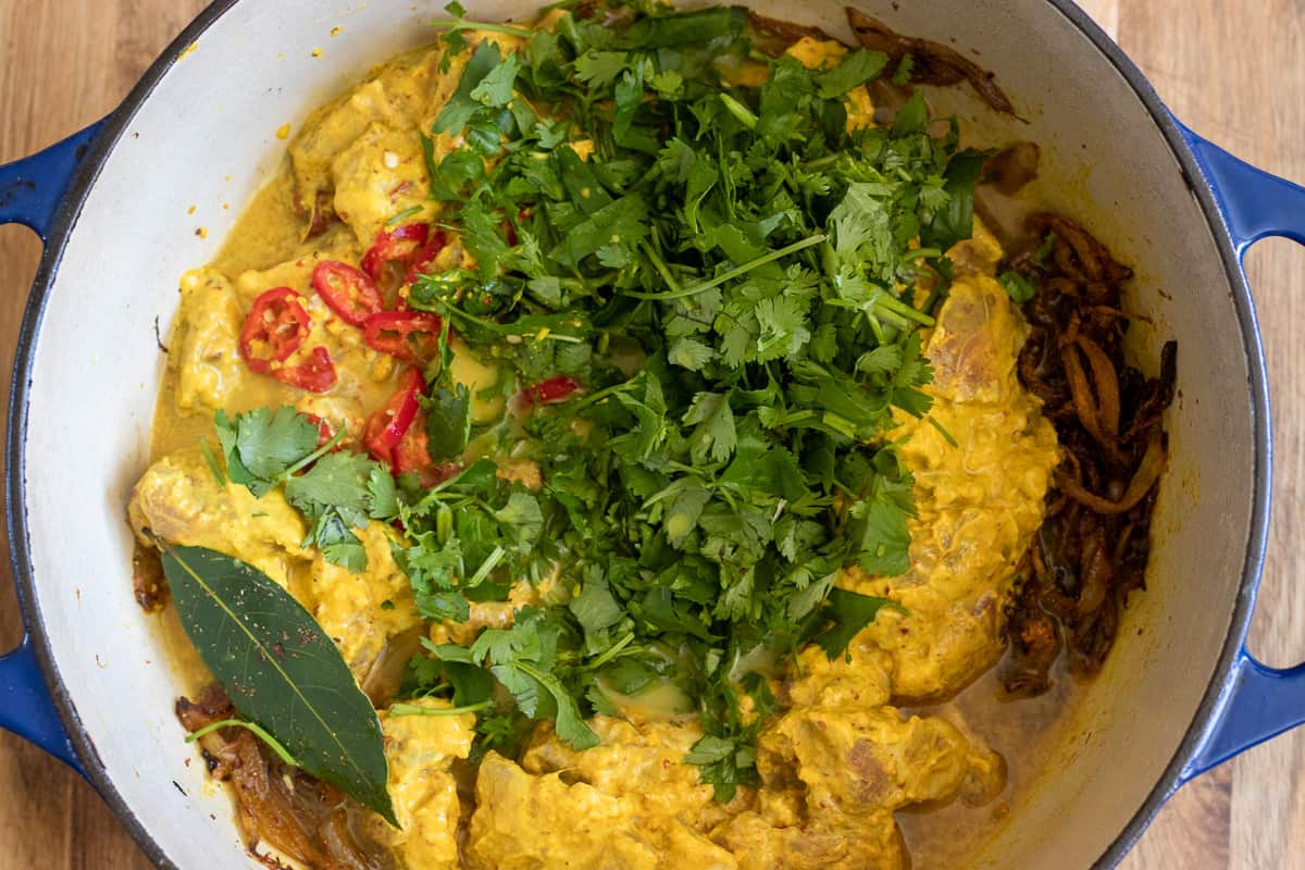 marinated mutton and coriander are added to the dutch oven