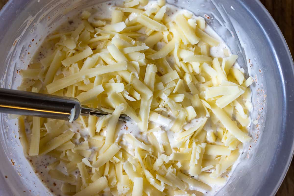 egg, cheese and double cream in a bowl with a whisk