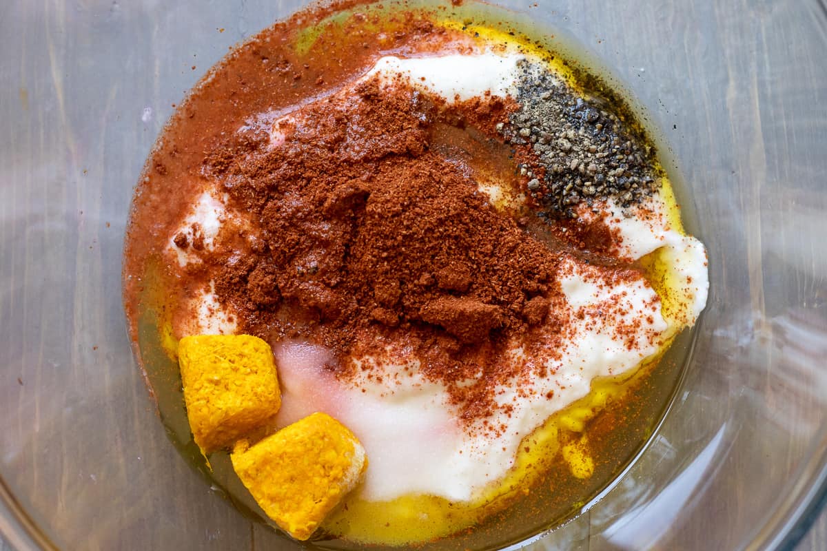 Ingredients for the marinate to make tandoori chicken are in a glass bowl