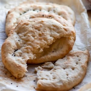 freshly baked roghni naan bread cut in half