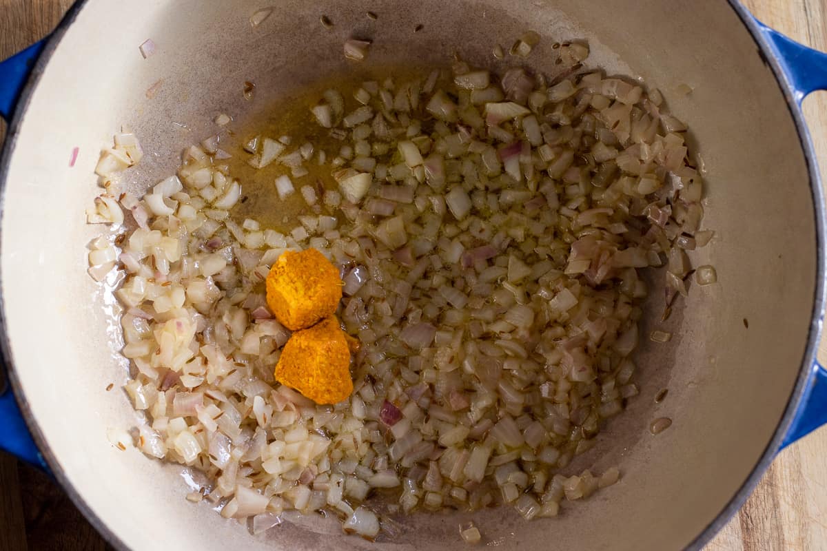 sautéing the garlic and ginger paste with cumin seeds and onions