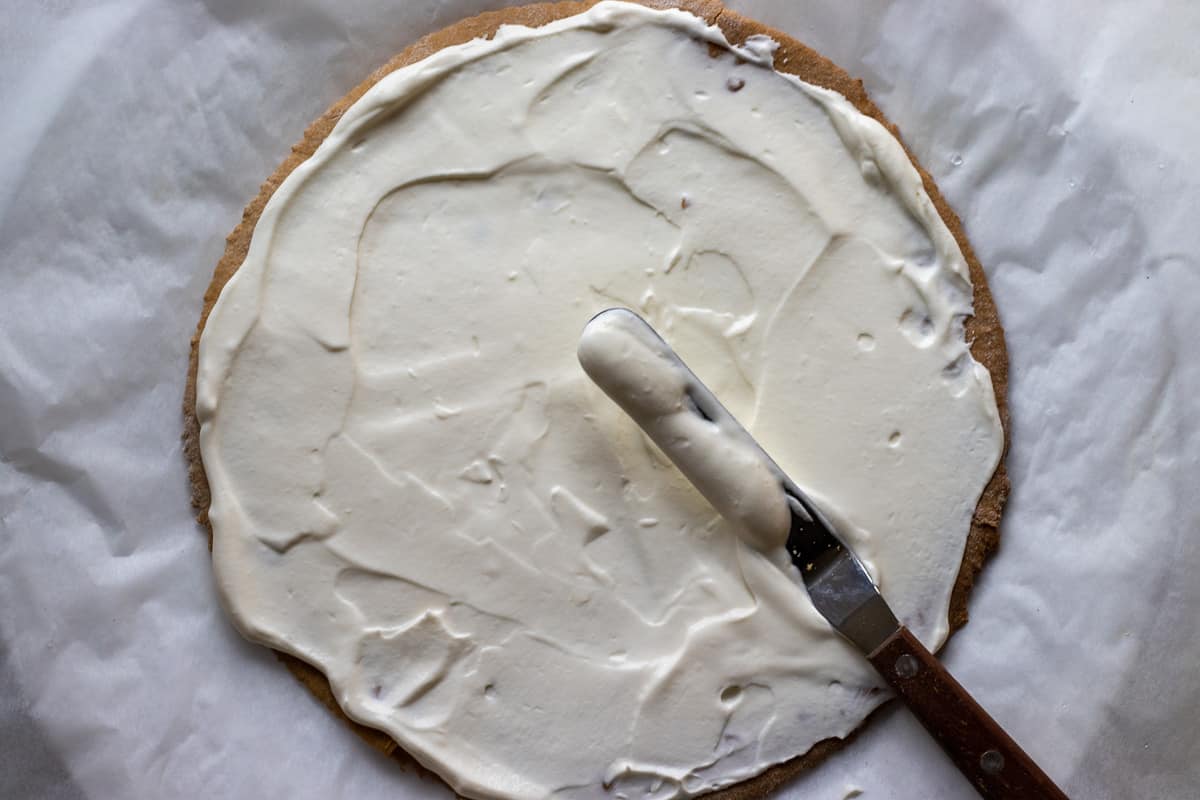 spreading some frosting on top of a cake layer