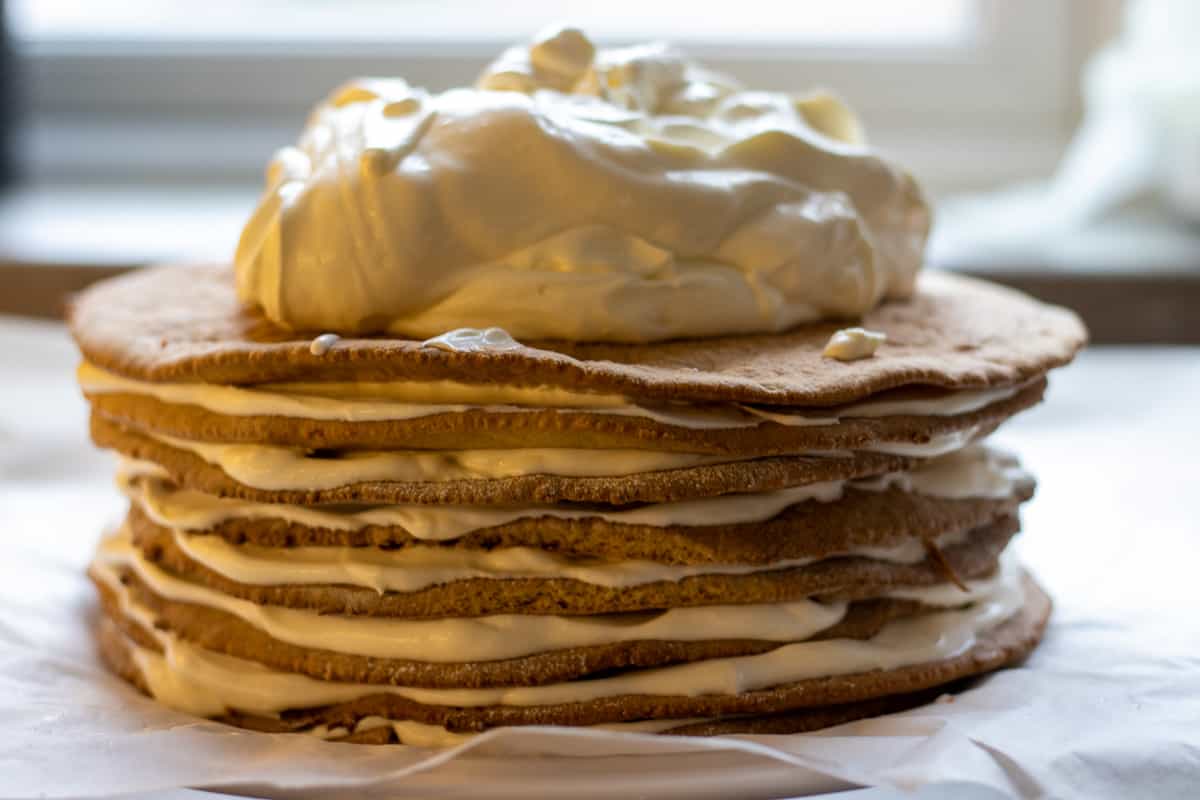 building the cake by spreading the frosting on all cake layers