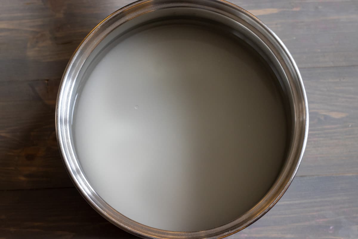 water and sugar are placed in a pan for making syrup