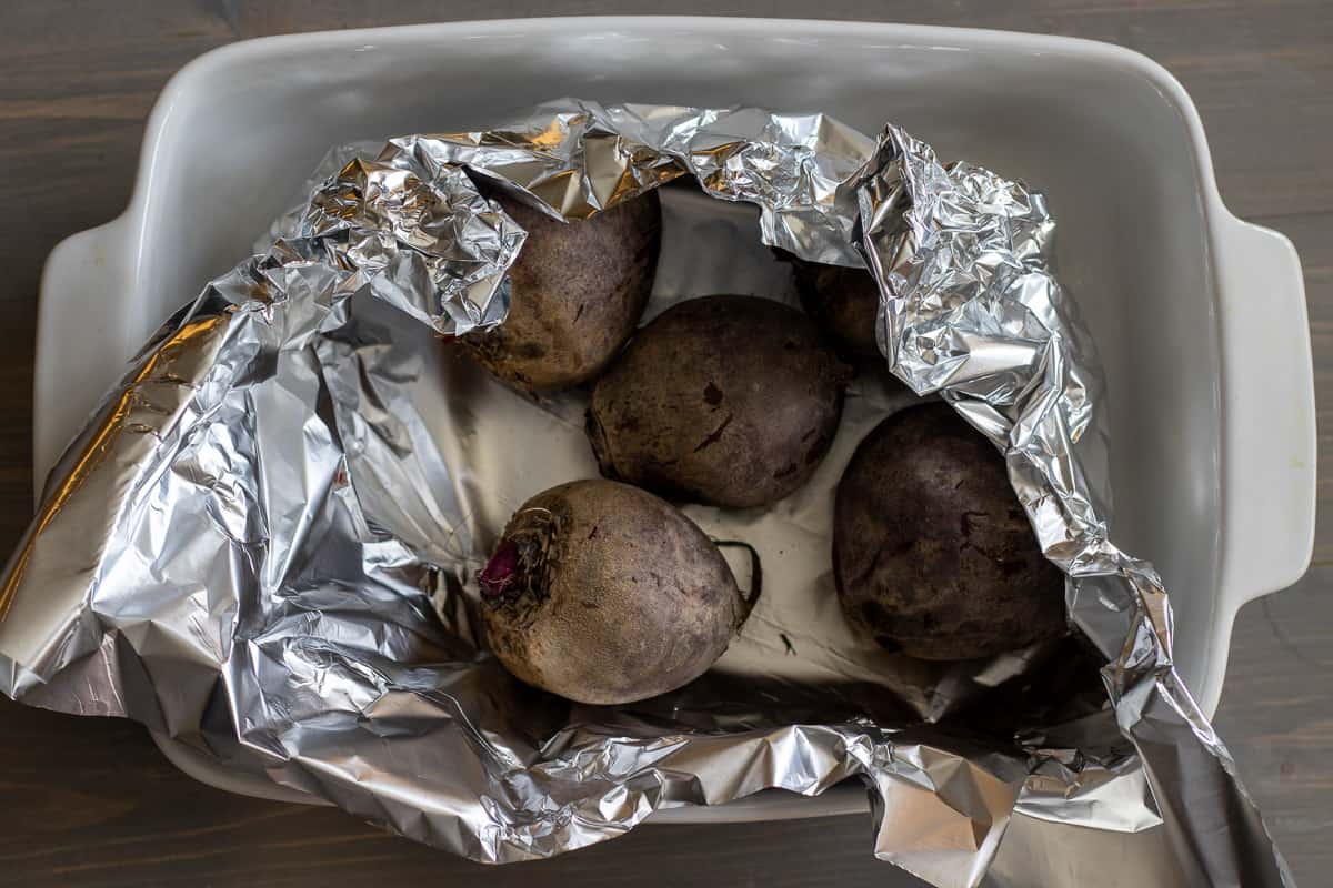 5 pieces of beets wrapped in tin foil for roasting.