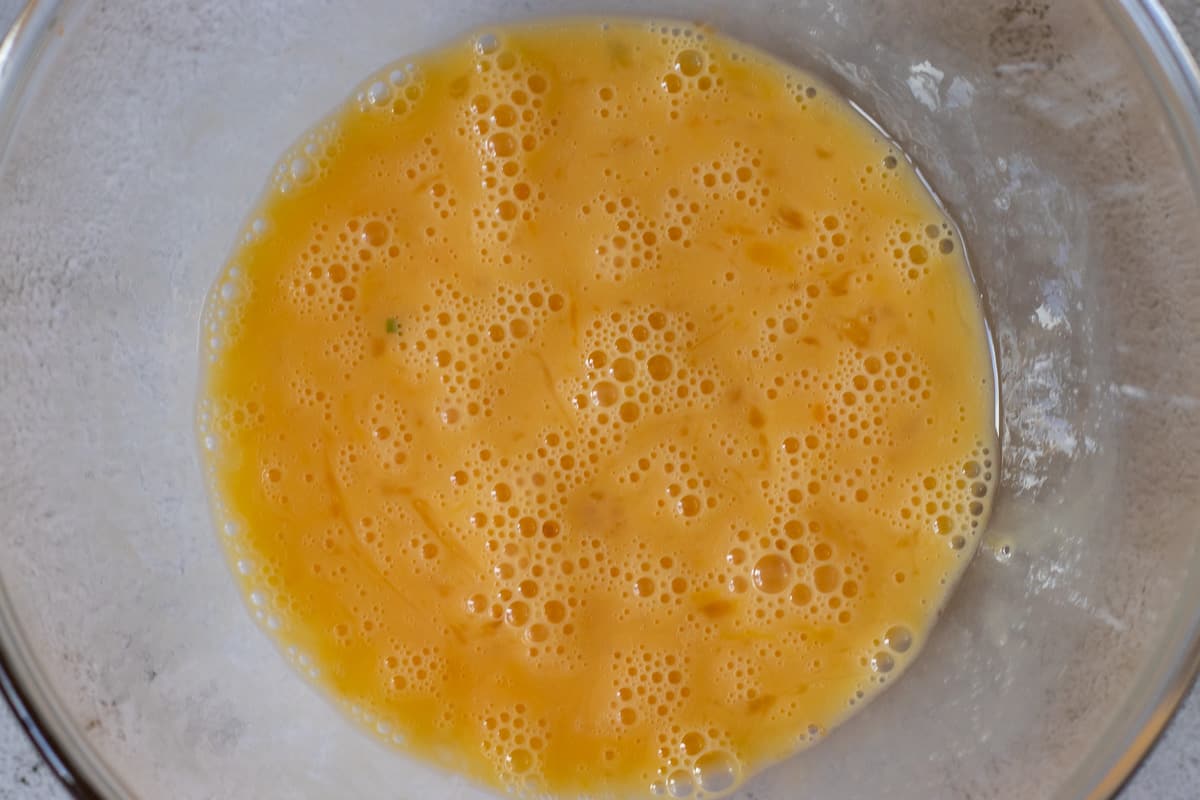 the eggs are cracked into a bowl and whisked until fluffy