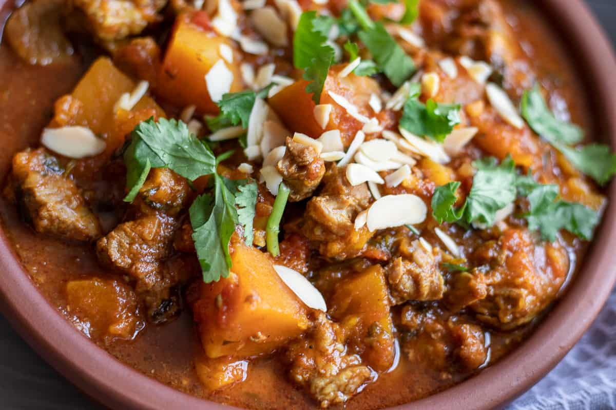 slow cooked lamb tagine garnished with coriander and almonds