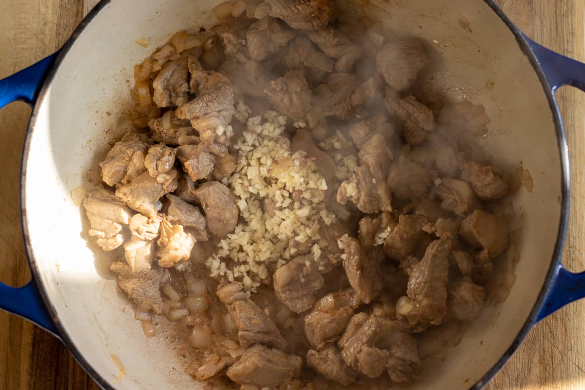 Sautéing the onions and garlic with browned lamb pieces