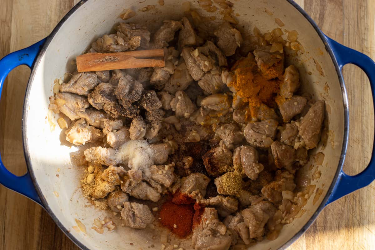 the spices are added to the sautéed lamb