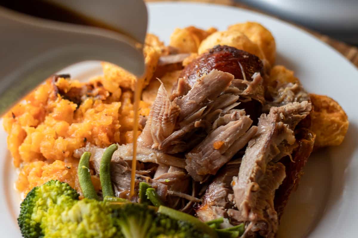 roasted turkey leg is served with side dishes and gravy