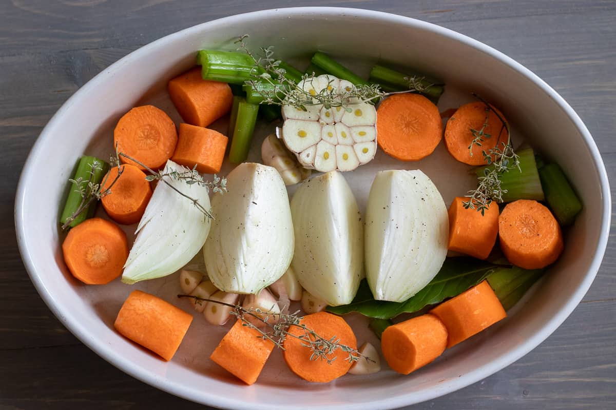 the vegetables and aromatics are placed in an oven dish
