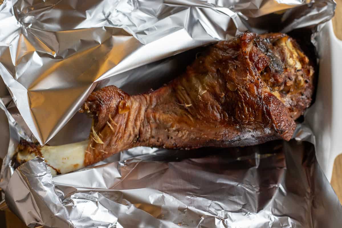 turkey leg is wrapped in tin foil for resting