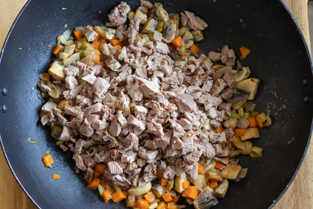 adding the turkey meat to sautéed vegetables