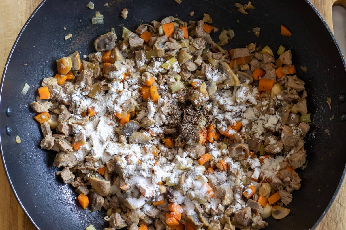 flour, thyme and seasoning are added to the wok
