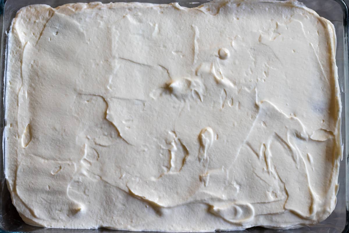 Mascarpone filling is spread evenly on top of biscuits