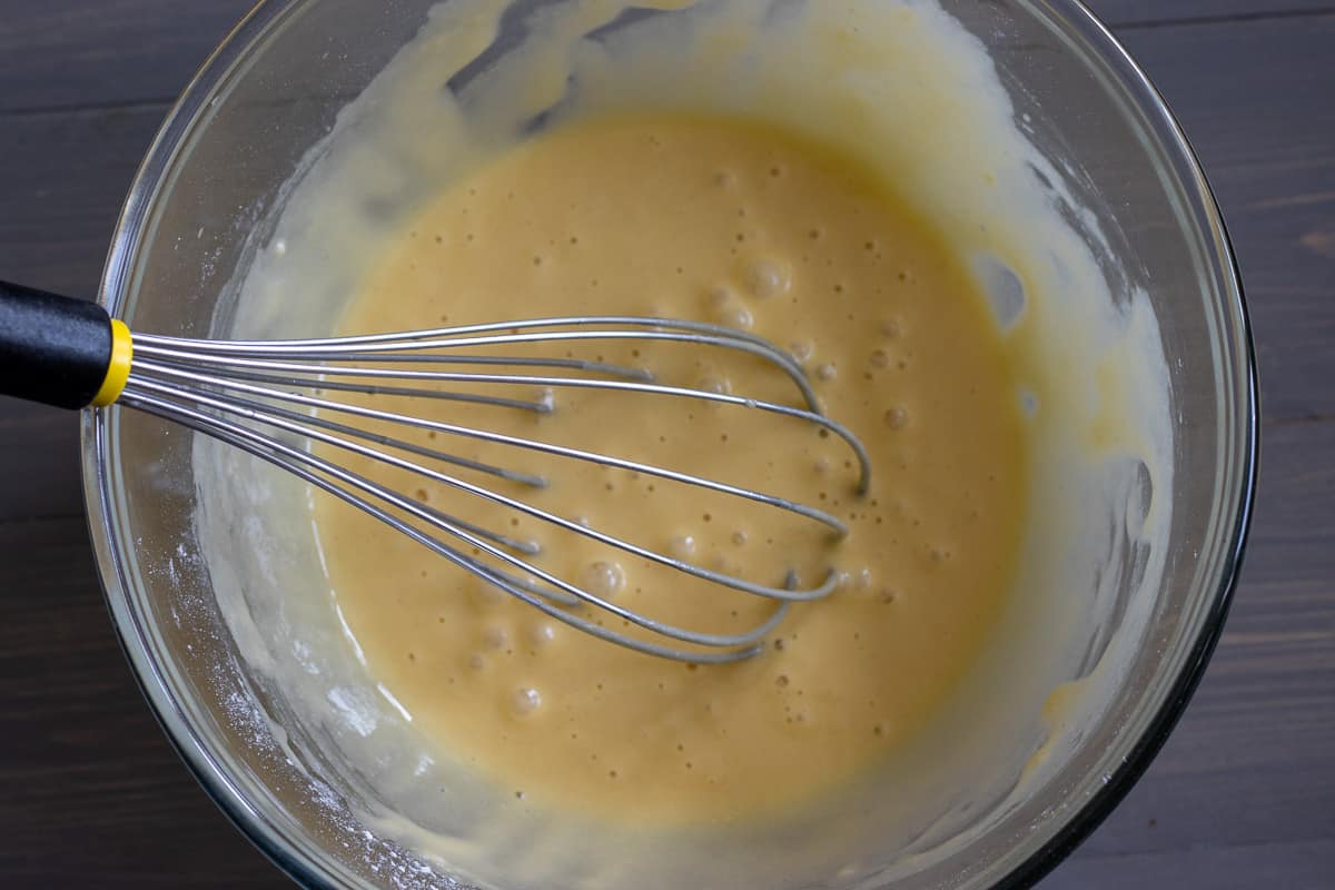 eggs and flour are whisked in a glass bowl