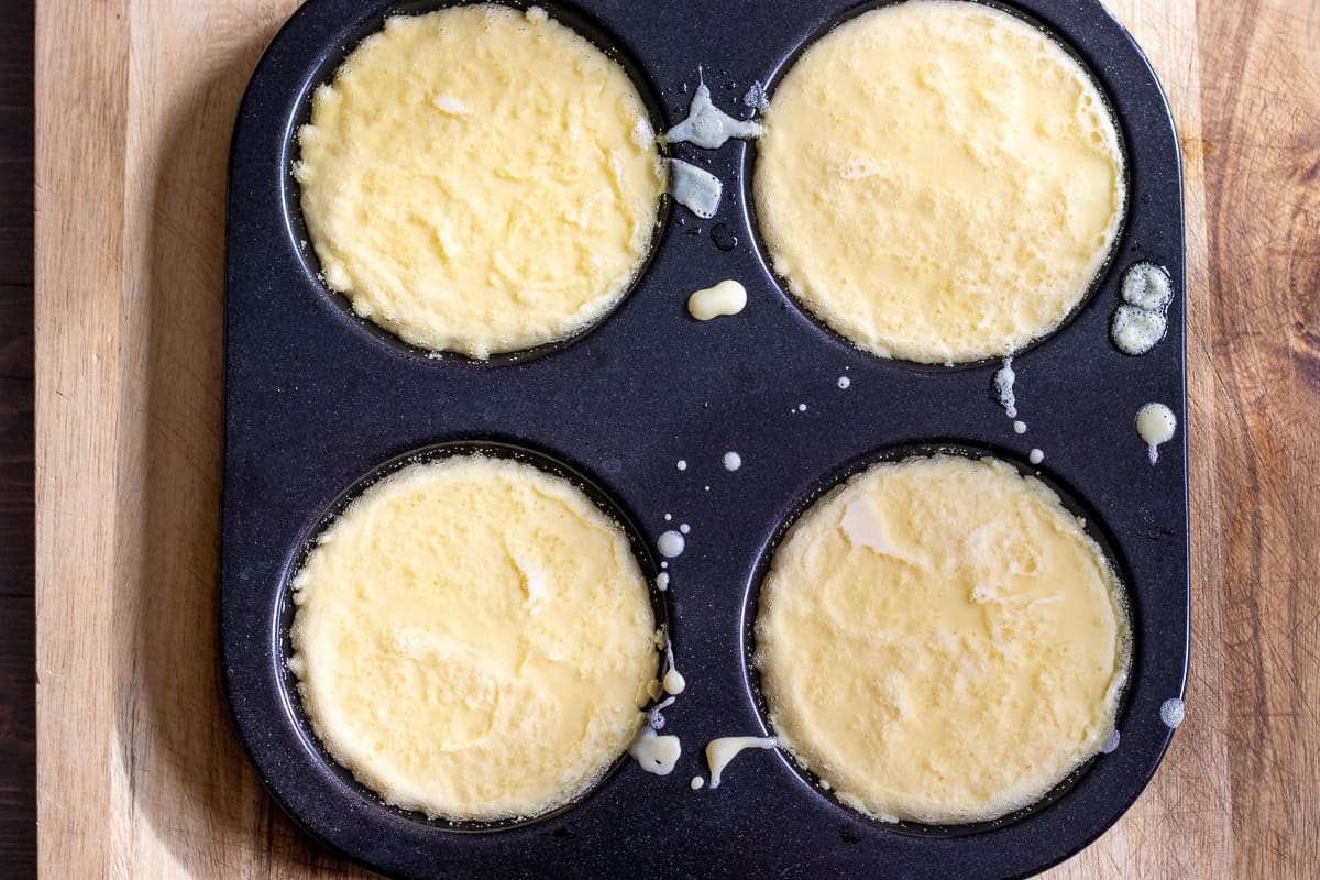 the batter is poured into hot oil filled holes