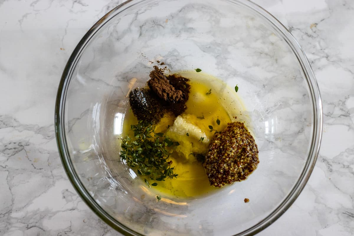 honey, mustard, garlic, thyme and spices are placed in a bowl