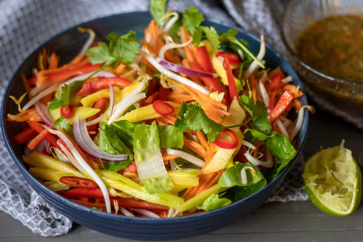 thai mango salad is served with the dressing on the side