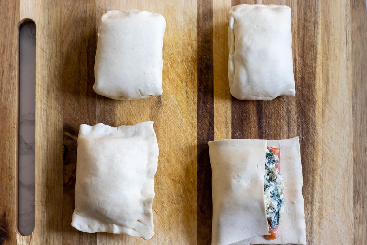 folding the empty side of the puff pastry on salmon pieces