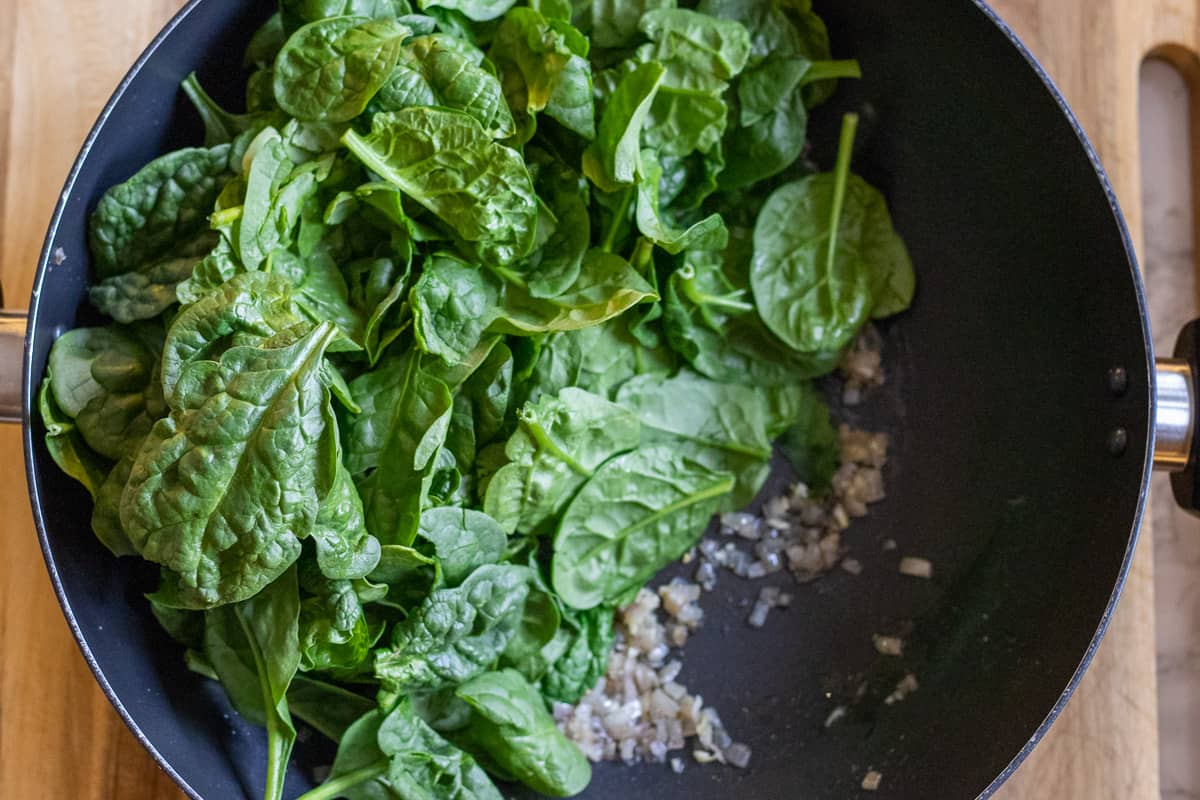 the spinach is added to the wok
