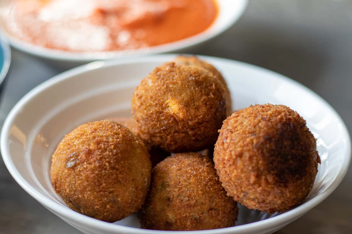 crispy and golden rice balls served in a bowl.