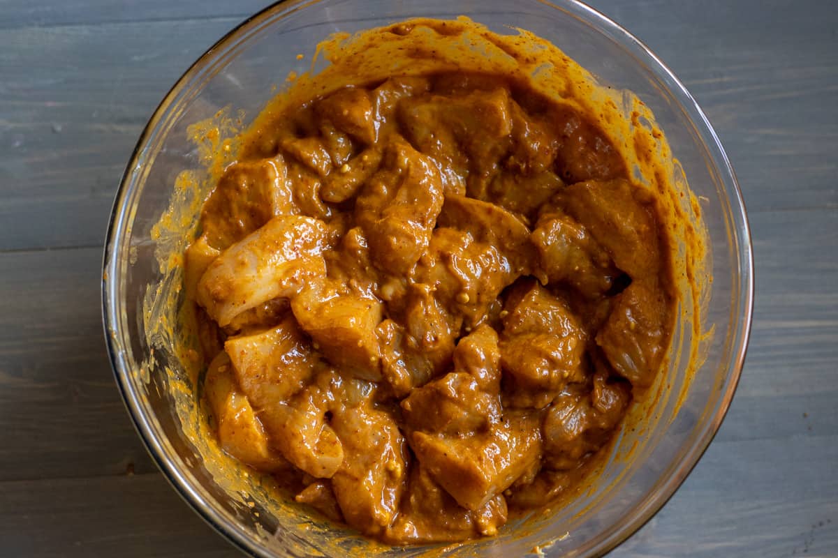Chicken pieces are placed with the marinade in a bowl.