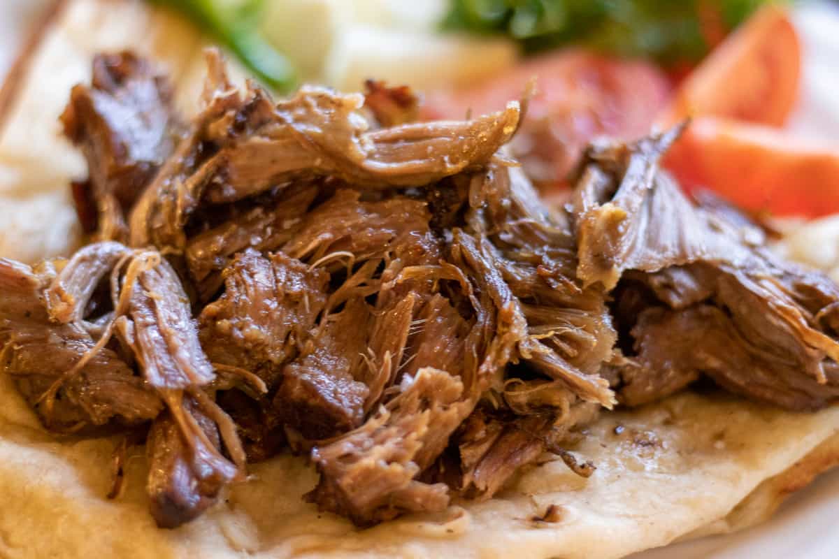 shredded lamb is served with pita bread