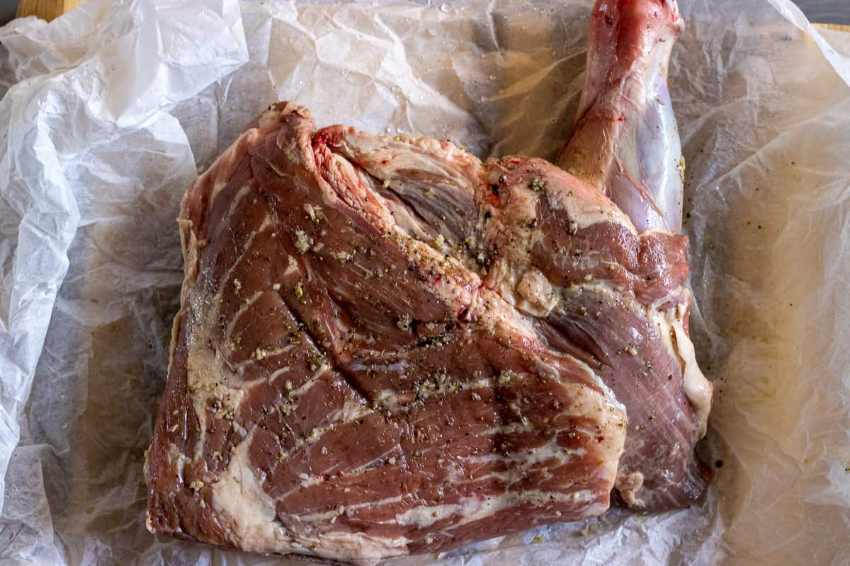 lamb shoulder is placed on a large parchment paper