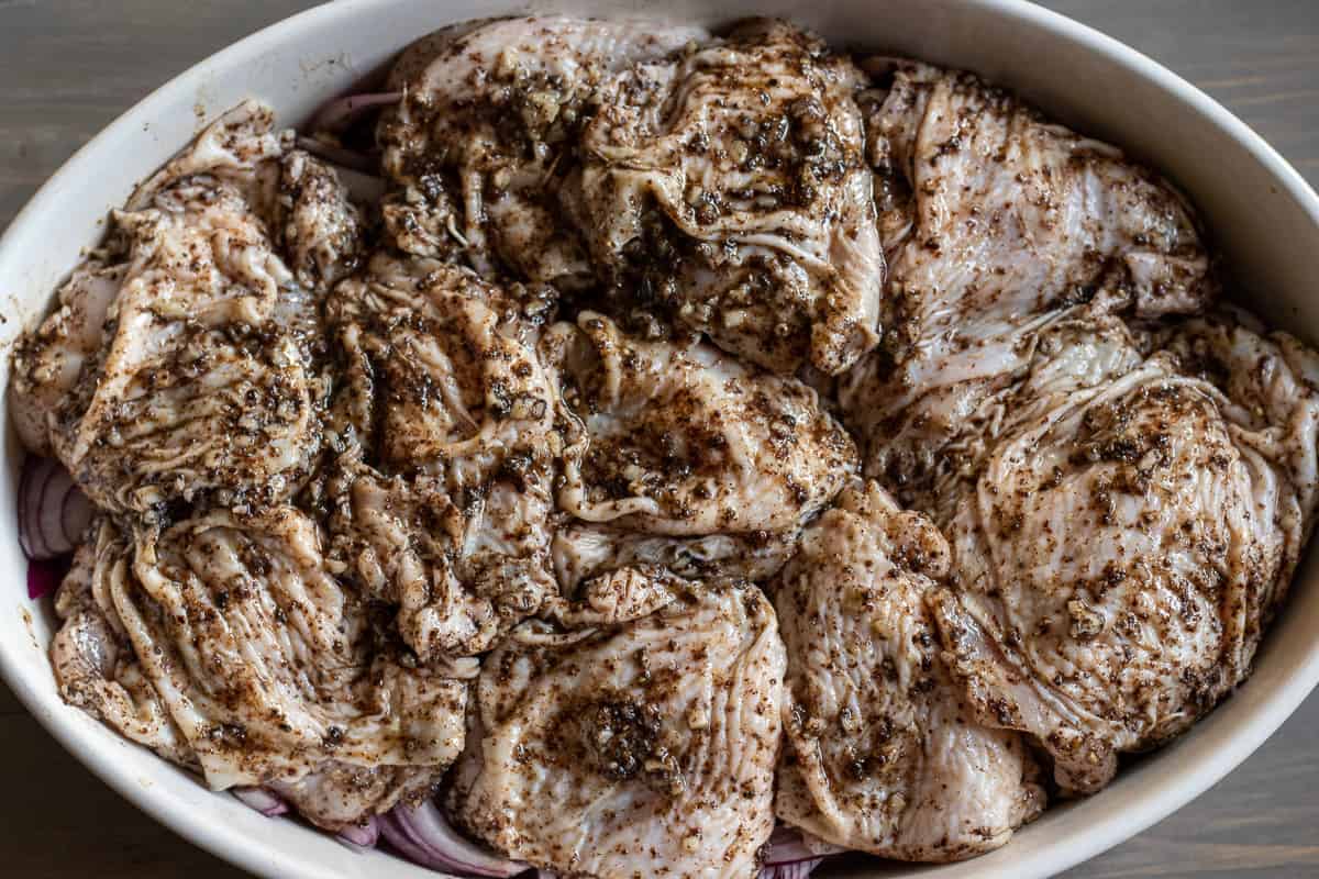 chicken pieces are placed on top of the onions