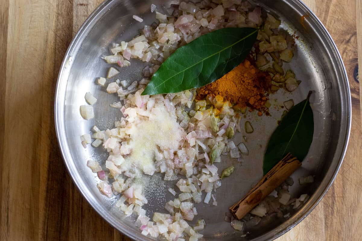 turmeric, bay leaves, cardamom and cinnamon stick are added to sautéed onions